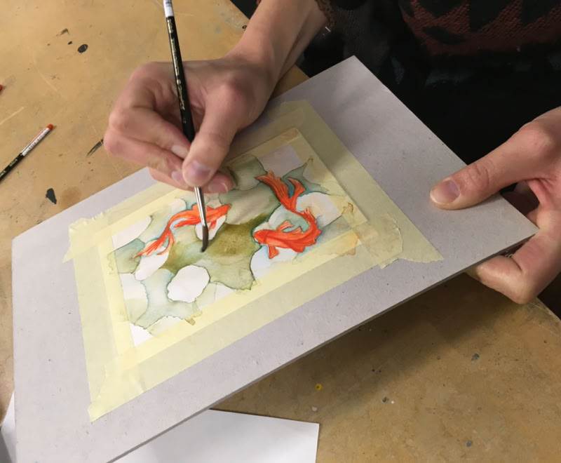 Peintures de visages de chats avec de grands yeux colorés, principalement violets et verts, disposées sur une surface.