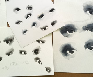 Plusieurs feuilles de papier avec des dessins d'yeux à l'encre noire.