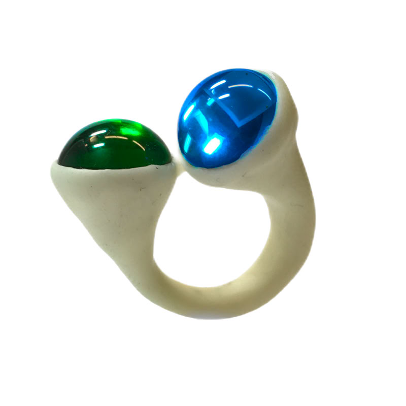 Bague en polymère blanche avec deux pierres, une verte et une bleue.
