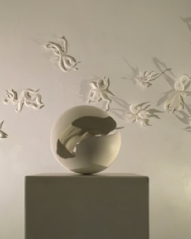 Sculpture en forme de sphère sur un socle, entourée de papillons blancs en relief sur un mur.
