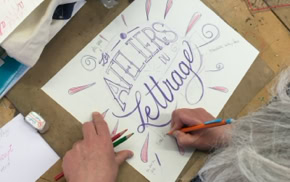 Personne faisant de la calligraphie sur une feuille de papier avec des crayons, avec les mots "ATELIERS de lettrage" visibles.