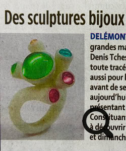 Une personne dessine sur une feuille de papier avec des crayons de couleur, représentant une maison colorée entourée d'oiseaux.