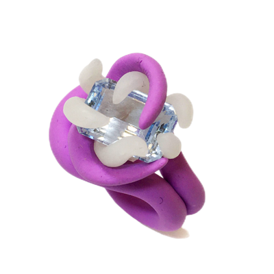 Bague violette avec une grande pierre bleue et des décorations blanches.