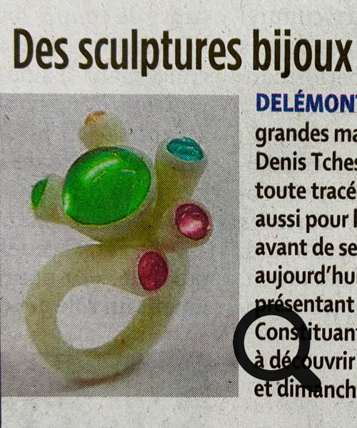 Une personne dessine sur une feuille de papier avec des crayons de couleur, représentant une maison colorée entourée d'oiseaux.