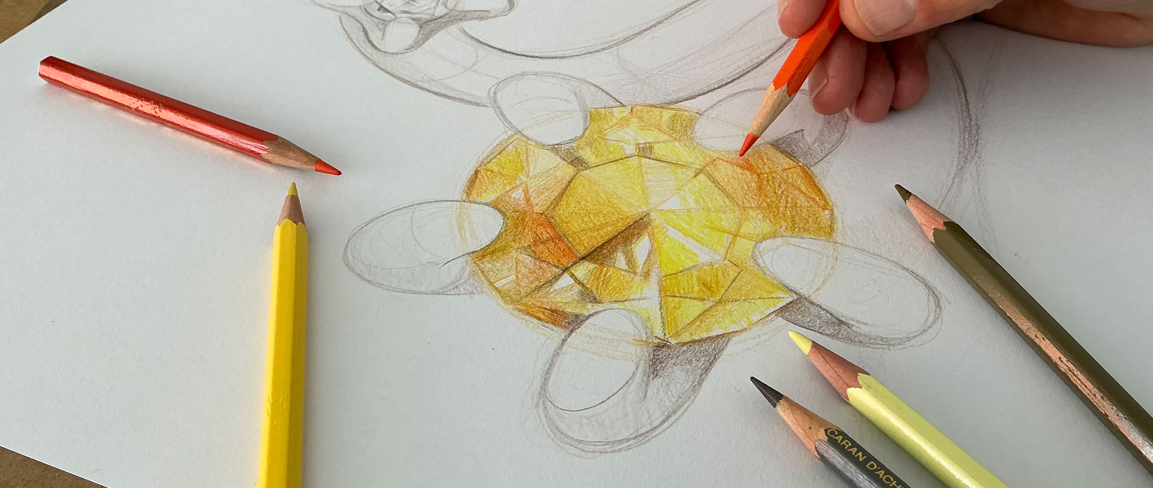 Dessin d'une pierre précieuse en cours de coloriage avec des crayons de couleur, main tenant un crayon orange.