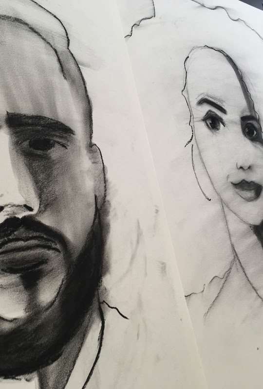 Dessins au fusain de plusieurs visages sur papier, montrant des traits expressifs et ombragés.