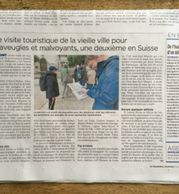 Une page de journal avec un article principal, une photo de deux personnes en extérieur, et plusieurs colonnes de texte.
