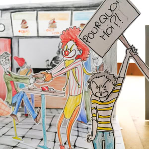 Illustration de personnages en papier dans un restaurant, l'un tenant une pancarte avec l'inscription "POURQUOI MOI?!".